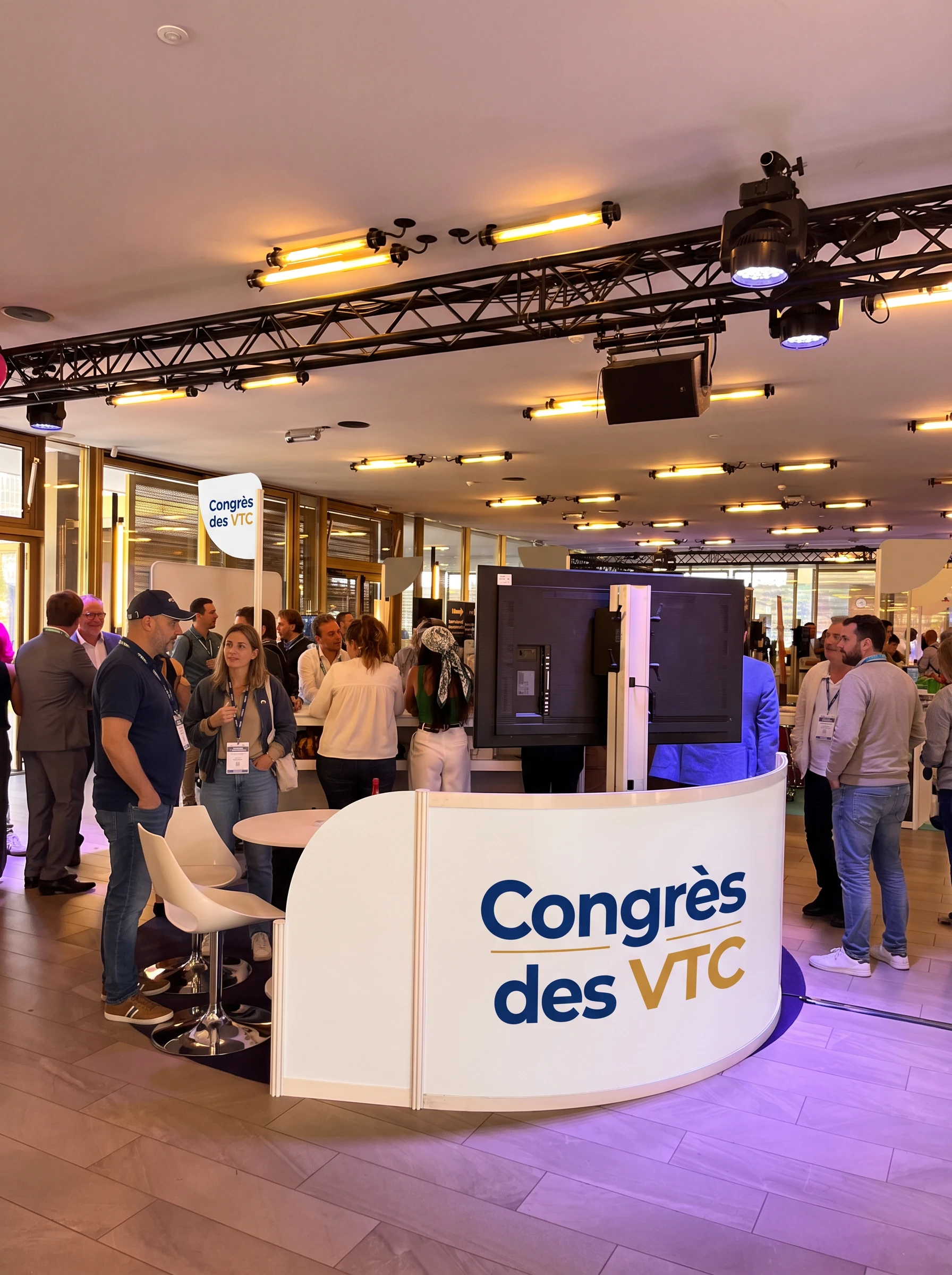 Stand au format Large avec comptoir cintré blanc brandé Congrès des VTC et espace de réception