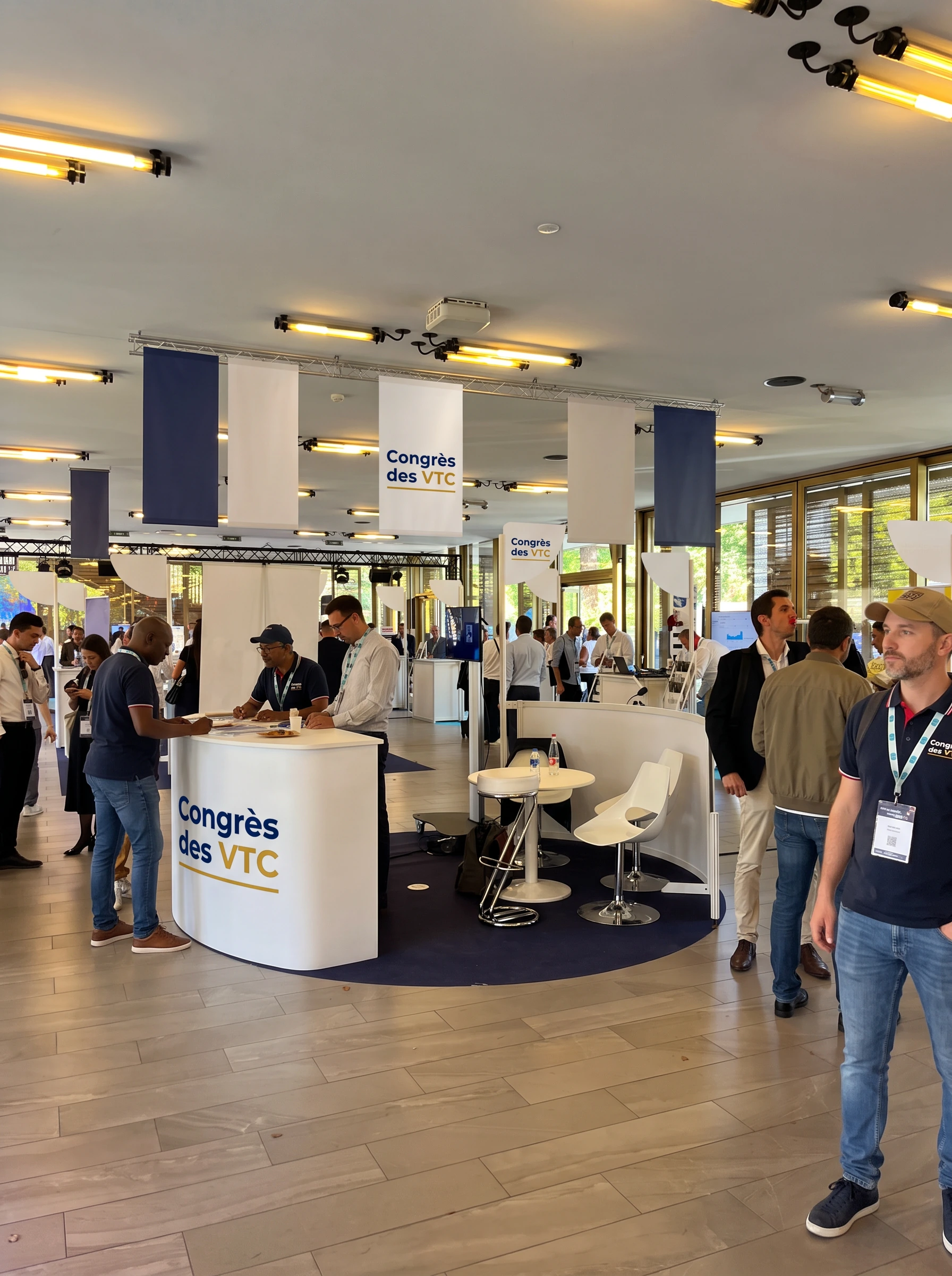 Stand partenaire officiel de 36 m² avec comptoir d'accueil blanc brandé Congrès des VTC et espace de réception