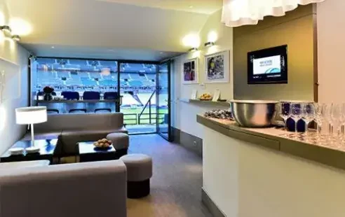 Loge privée du Stade de France avec vue sur la pelouse, salon lounge et téléviseur connectable en HDMI